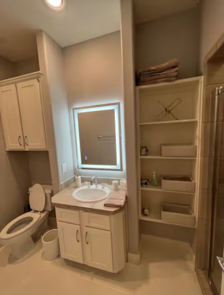 Bathroom with lit mirror in Houston